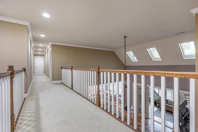 hallway with light colored carpet, crown molding, and vaulted ceiling with skylight