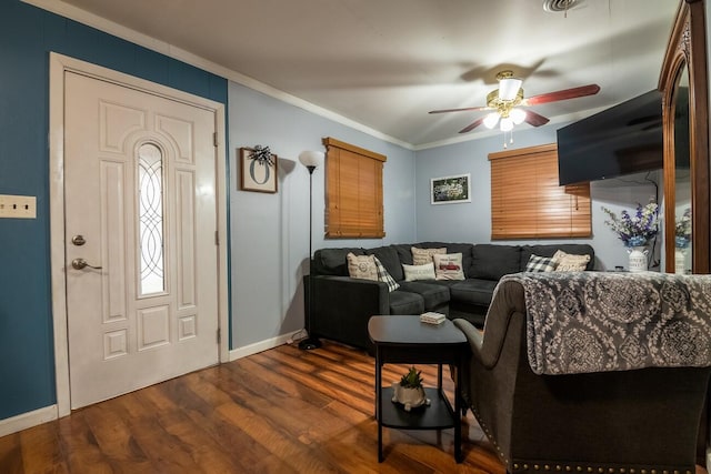 living room with crown molding, dark hardwood / wood-style flooring, and ceiling fan