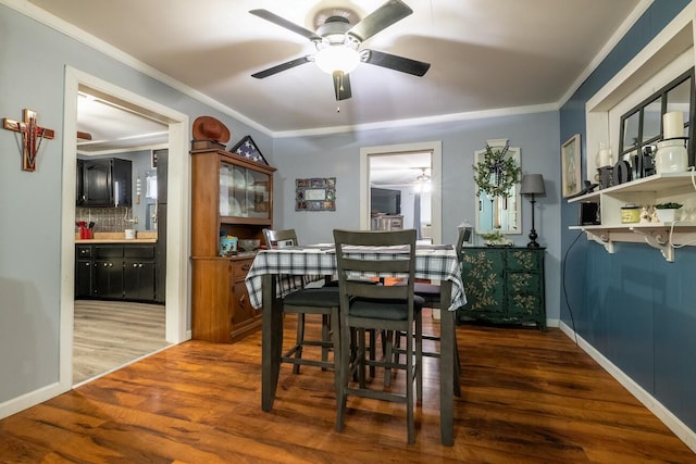 dining room with ceiling fan, dark wood-type flooring, and ornamental molding