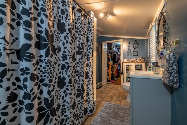 bathroom with vanity, toilet, and ornamental molding