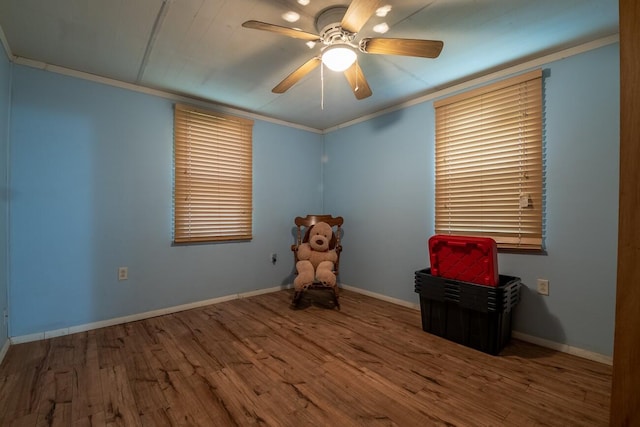 interior space with ceiling fan, wood-type flooring, and ornamental molding