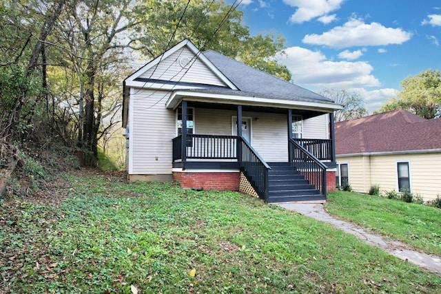 bungalow-style house featuring covered porch and a front yard