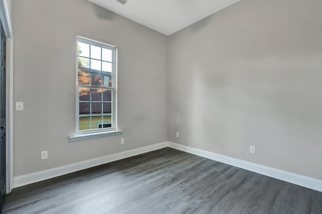 unfurnished room with dark hardwood / wood-style flooring