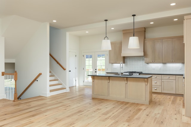 kitchen with pendant lighting, light brown cabinets, light wood-type flooring, and sink