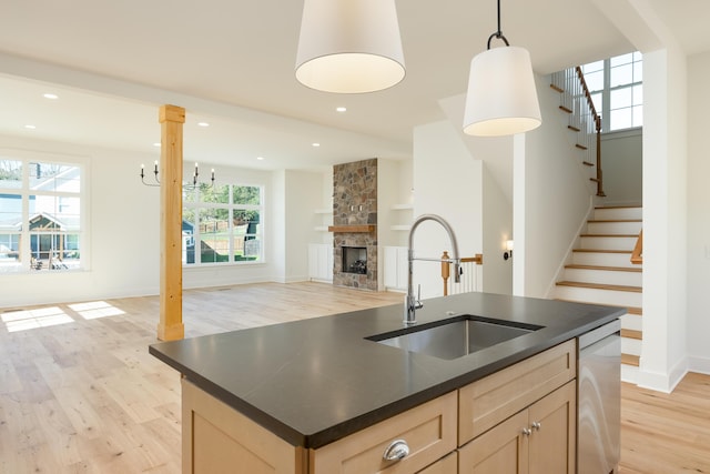 kitchen with pendant lighting, plenty of natural light, light hardwood / wood-style floors, and sink