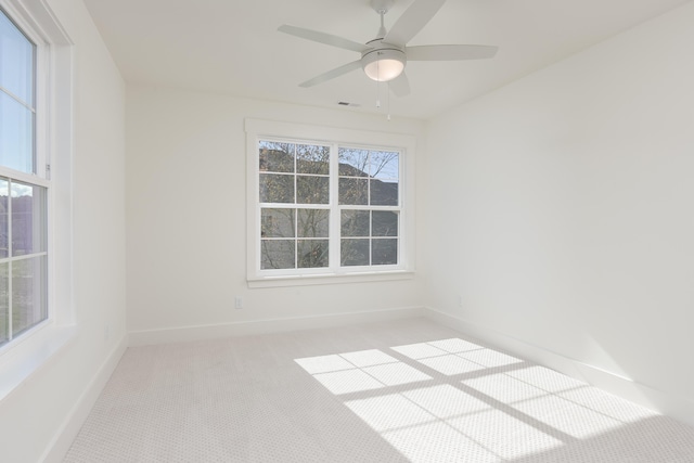 spare room featuring light carpet and ceiling fan