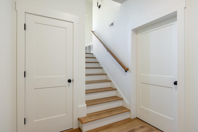 stairs featuring hardwood / wood-style floors