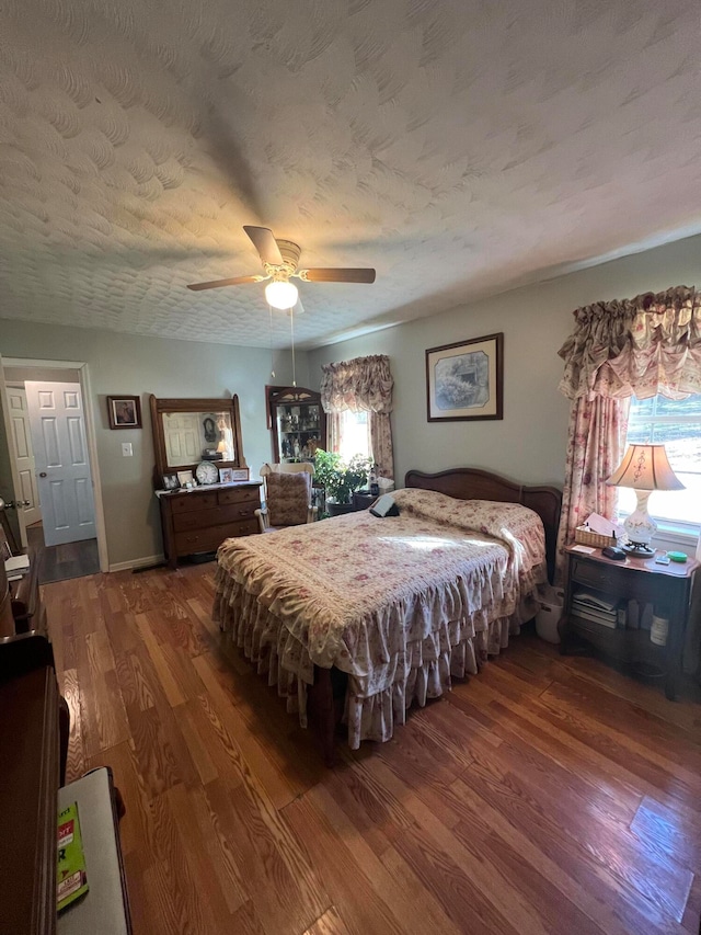 bedroom with multiple windows, hardwood / wood-style flooring, and ceiling fan