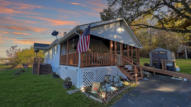 exterior space with covered porch, a yard, and a shed