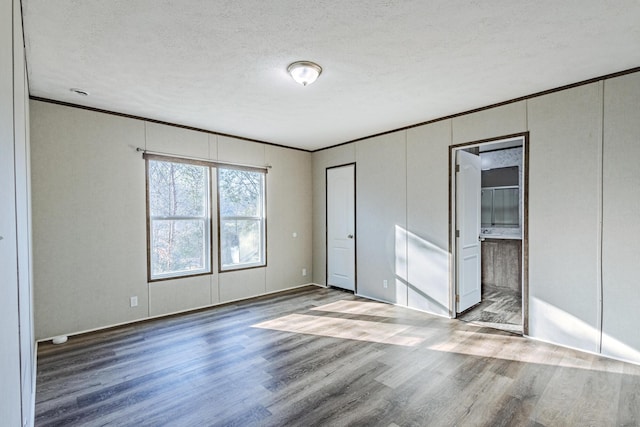 1418 County Road 700, Athens, TN 37303 - unfurnished bedroom featuring connected bathroom, a textured ceiling, wood finished floors, and crown molding