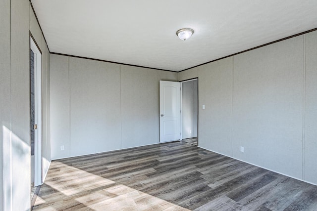 unfurnished bedroom featuring crown molding and wood finished floors