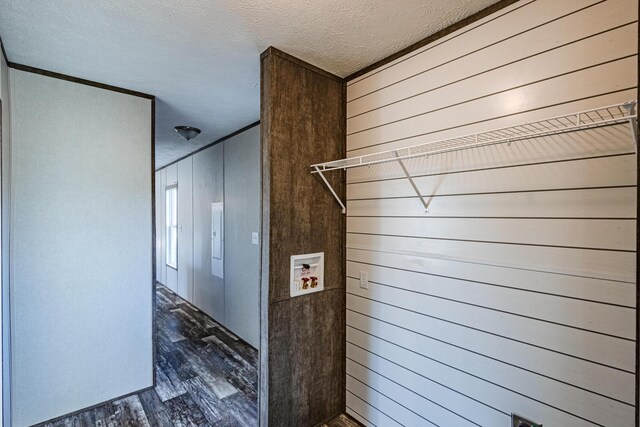 interior space with wooden walls, a textured ceiling, and wood finished floors