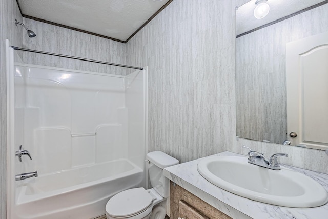 bathroom with a textured ceiling, bathtub / shower combination, vanity, and toilet