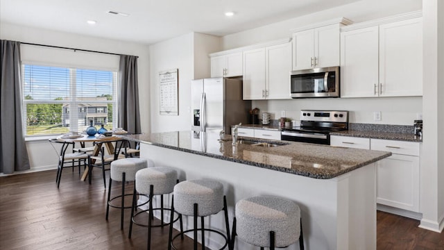 kitchen featuring sink, stainless steel appliances, dark hardwood / wood-style floors, a kitchen island with sink, and white cabinets