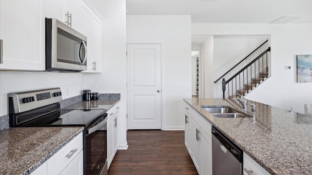 kitchen featuring sink, dark hardwood / wood-style flooring, light stone counters, white cabinetry, and stainless steel appliances