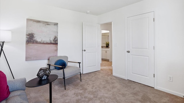 living area featuring light carpet