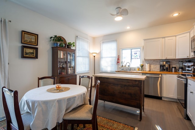 kitchen with white cabinetry, tasteful backsplash, light hardwood / wood-style floors, butcher block counters, and stainless steel appliances