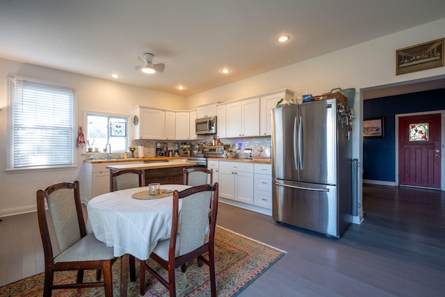 kitchen featuring dark hardwood / wood-style flooring, wooden counters, decorative backsplash, white cabinets, and appliances with stainless steel finishes