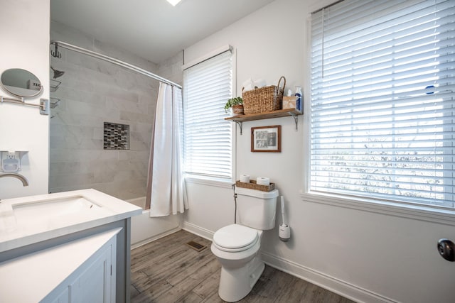 full bathroom with hardwood / wood-style floors, vanity, toilet, and shower / bath combo