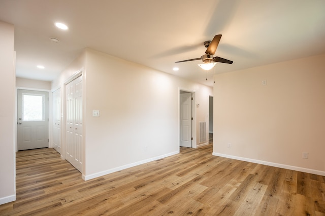 empty room with ceiling fan and light hardwood / wood-style flooring