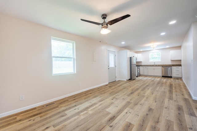 unfurnished living room with ceiling fan, light hardwood / wood-style flooring, and sink