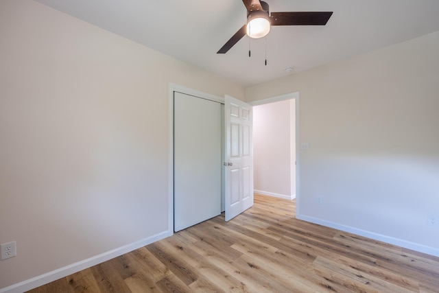 unfurnished bedroom featuring ceiling fan, a closet, and light hardwood / wood-style flooring