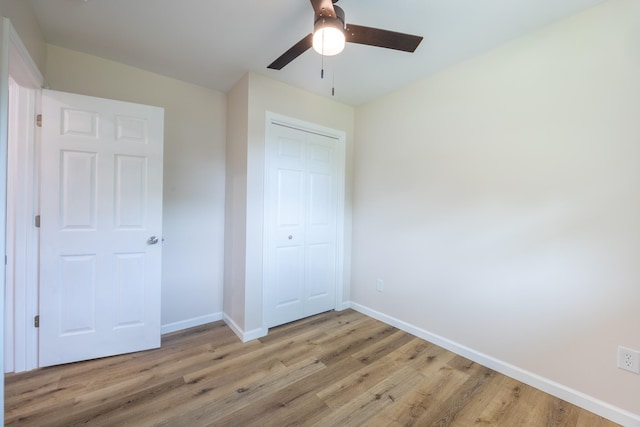 unfurnished bedroom featuring ceiling fan, a closet, and light hardwood / wood-style floors