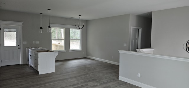 kitchen with hanging light fixtures, dark hardwood / wood-style floors, a notable chandelier, white cabinets, and kitchen peninsula