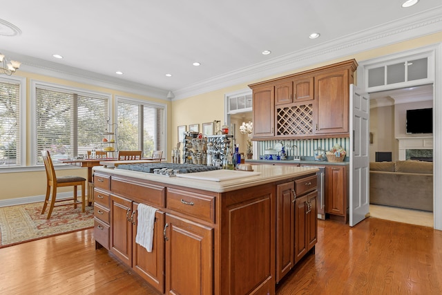 kitchen with plenty of natural light, a kitchen island, ornamental molding, and hardwood / wood-style flooring