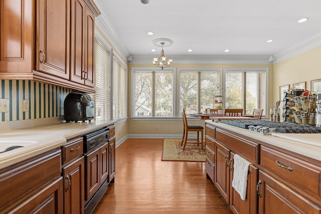 kitchen with a wealth of natural light, crown molding, light hardwood / wood-style floors, and an inviting chandelier