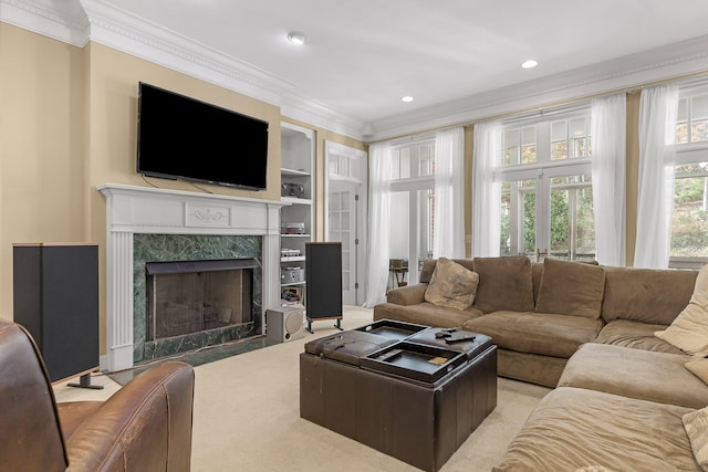 carpeted living room featuring built in shelves, a premium fireplace, french doors, and ornamental molding