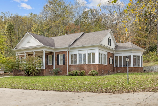 view of front facade featuring a sunroom and a front yard