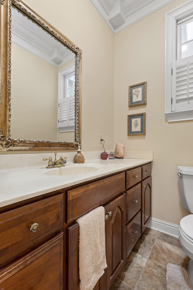 bathroom with vanity, toilet, and ornamental molding