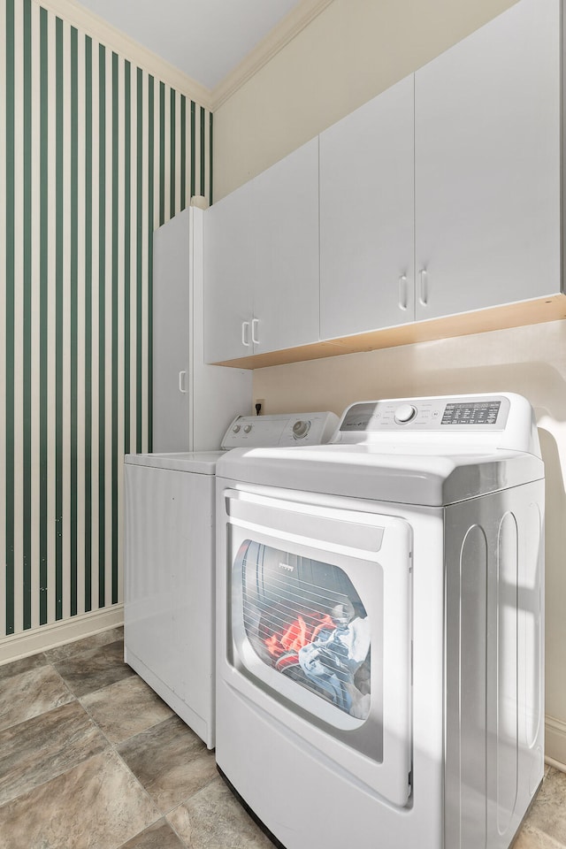 laundry room with cabinets, crown molding, and washing machine and clothes dryer