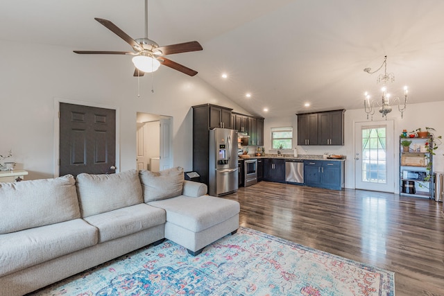 living room with hardwood / wood-style floors, ceiling fan with notable chandelier, and high vaulted ceiling