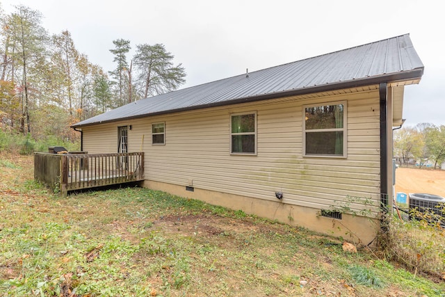 rear view of property with a wooden deck and central AC