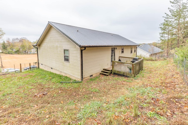 back of property with a lawn and a wooden deck