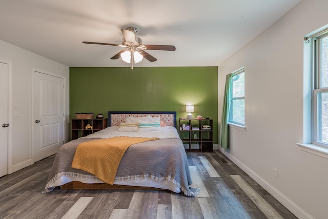 bedroom featuring multiple windows, ceiling fan, and dark hardwood / wood-style flooring