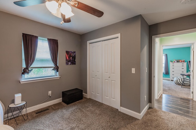 unfurnished bedroom featuring carpet flooring, ceiling fan, and a closet