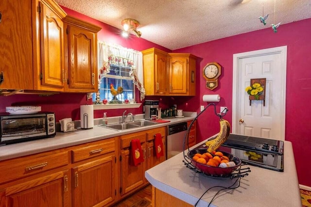 kitchen with wood-type flooring, a textured ceiling, stainless steel dishwasher, and sink