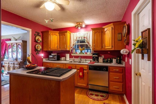 kitchen with sink, stainless steel dishwasher, ceiling fan, light wood-type flooring, and a textured ceiling