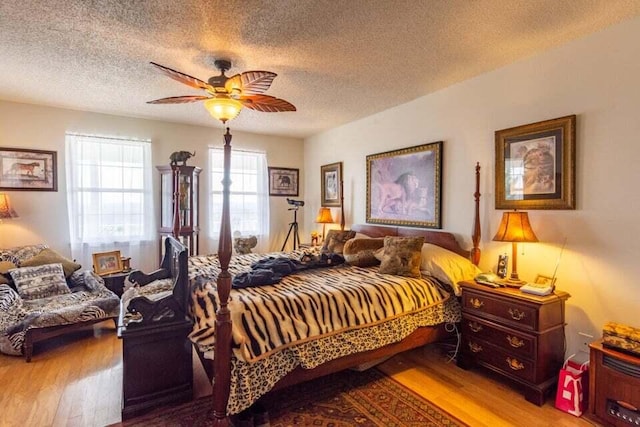 bedroom featuring ceiling fan, light hardwood / wood-style floors, and a textured ceiling