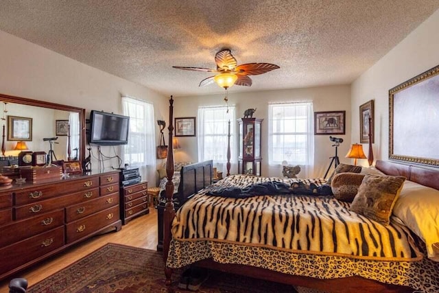 bedroom featuring a textured ceiling, light hardwood / wood-style flooring, and ceiling fan