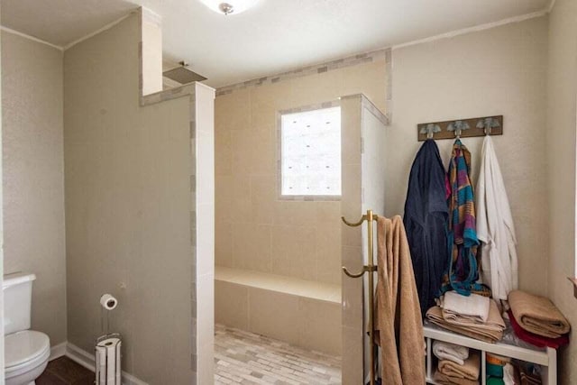 bathroom featuring toilet and tiled shower