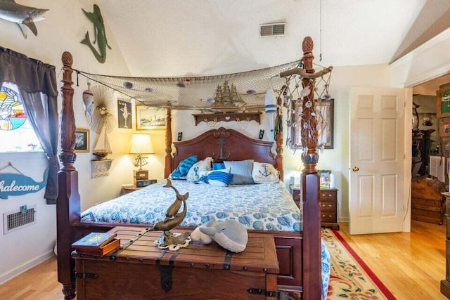 bedroom with hardwood / wood-style floors and vaulted ceiling