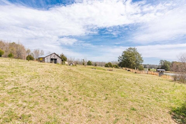 view of yard with a rural view and an outdoor structure