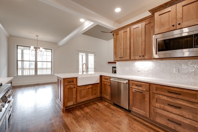 kitchen featuring kitchen peninsula, a wealth of natural light, sink, and appliances with stainless steel finishes