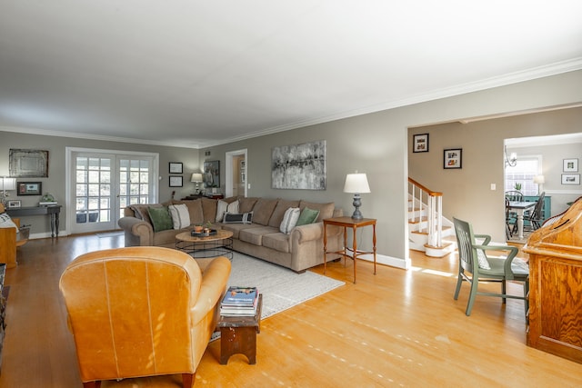 living room with light wood-type flooring, an inviting chandelier, and crown molding