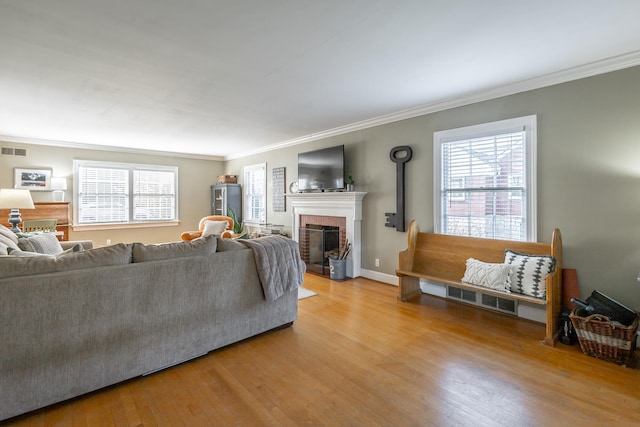 living room with light wood-type flooring and ornamental molding