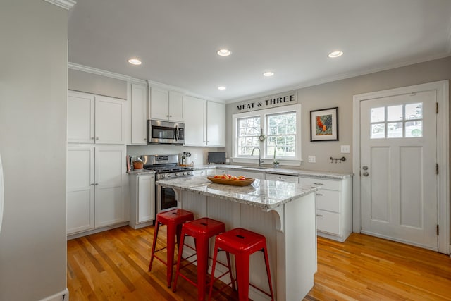 kitchen featuring a wealth of natural light, a center island, stainless steel appliances, and light wood-type flooring